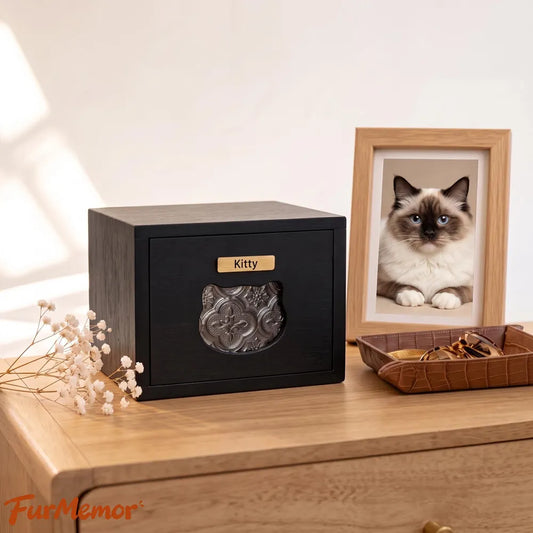 Personalized wooden pet urn for cats with custom name displayed beside a memorial photo