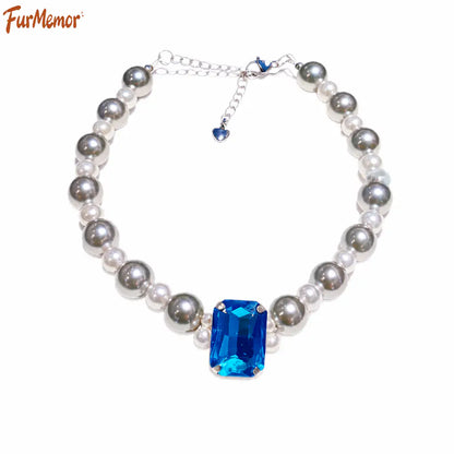 Close-up of crystal charm and pearl details on pet necklace